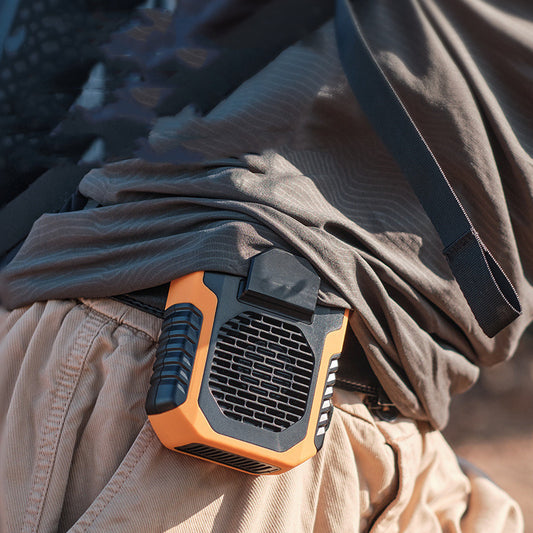 Portable fan attached to a person's belt with a blurred background