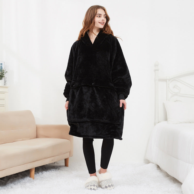 Woman wearing a black fleece robe in a minimalistic room.