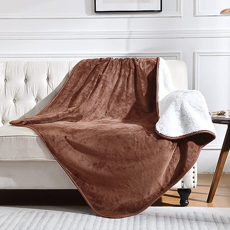 Brown blanket draped over a white sofa in a living room setting.