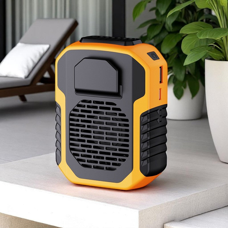 Orange and black portable air conditioner on a table with a plant and chair in the background