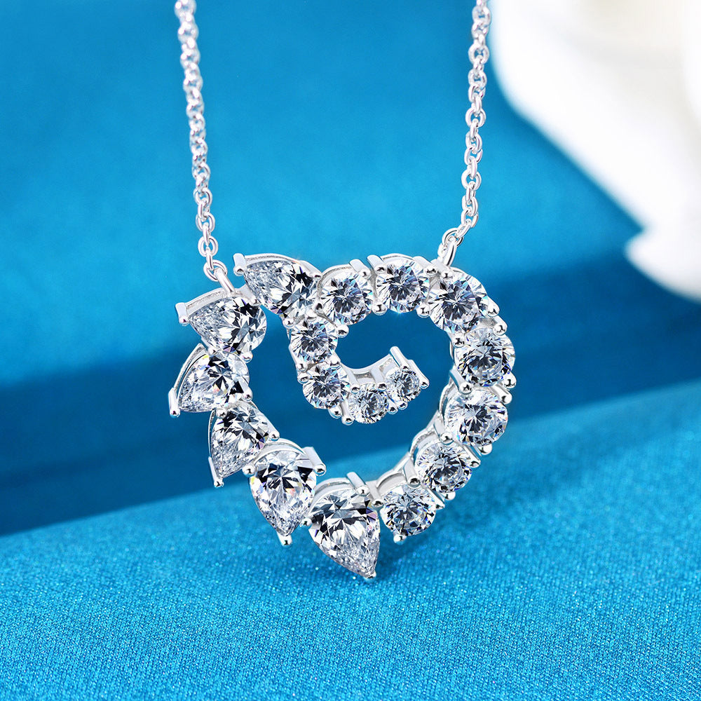 A silver necklace with an elegant floral heart design pendant, featuring clear stones.