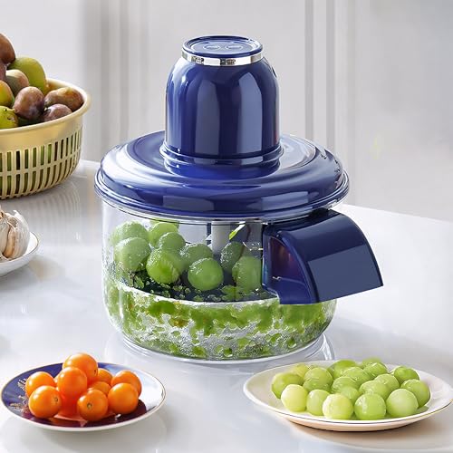 Blue manual juicer with grapes being juiced on a white surface.
