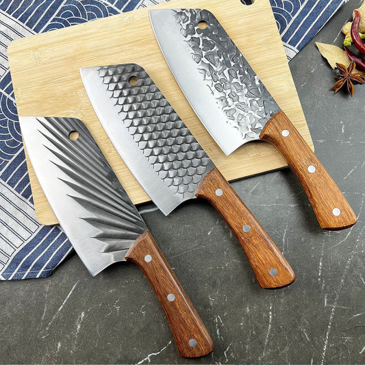 Three chef's knives with wooden handles on a wooden cutting board against a patterned cloth background.