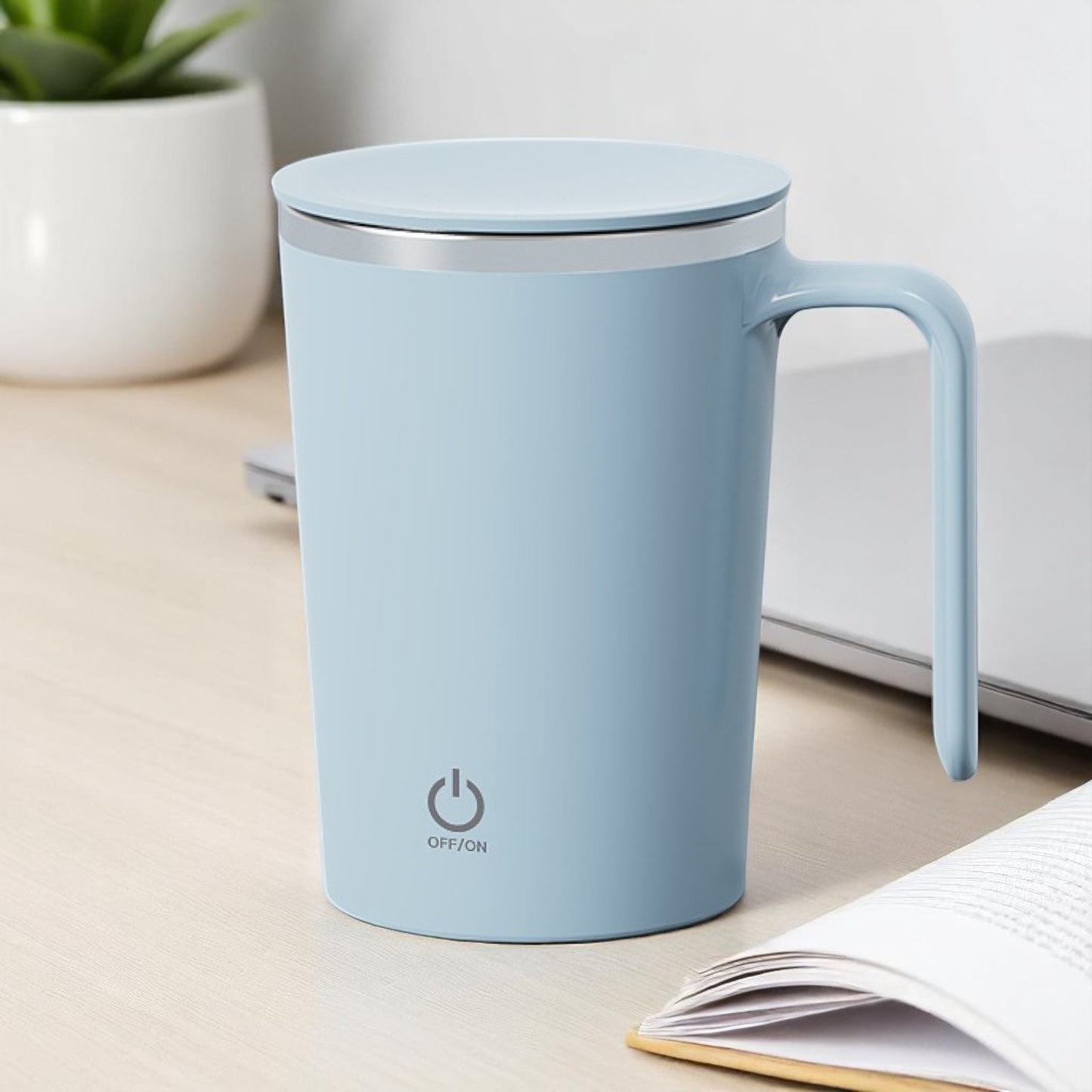 Light blue mug with a power symbol on a desk with a plant and notebook.