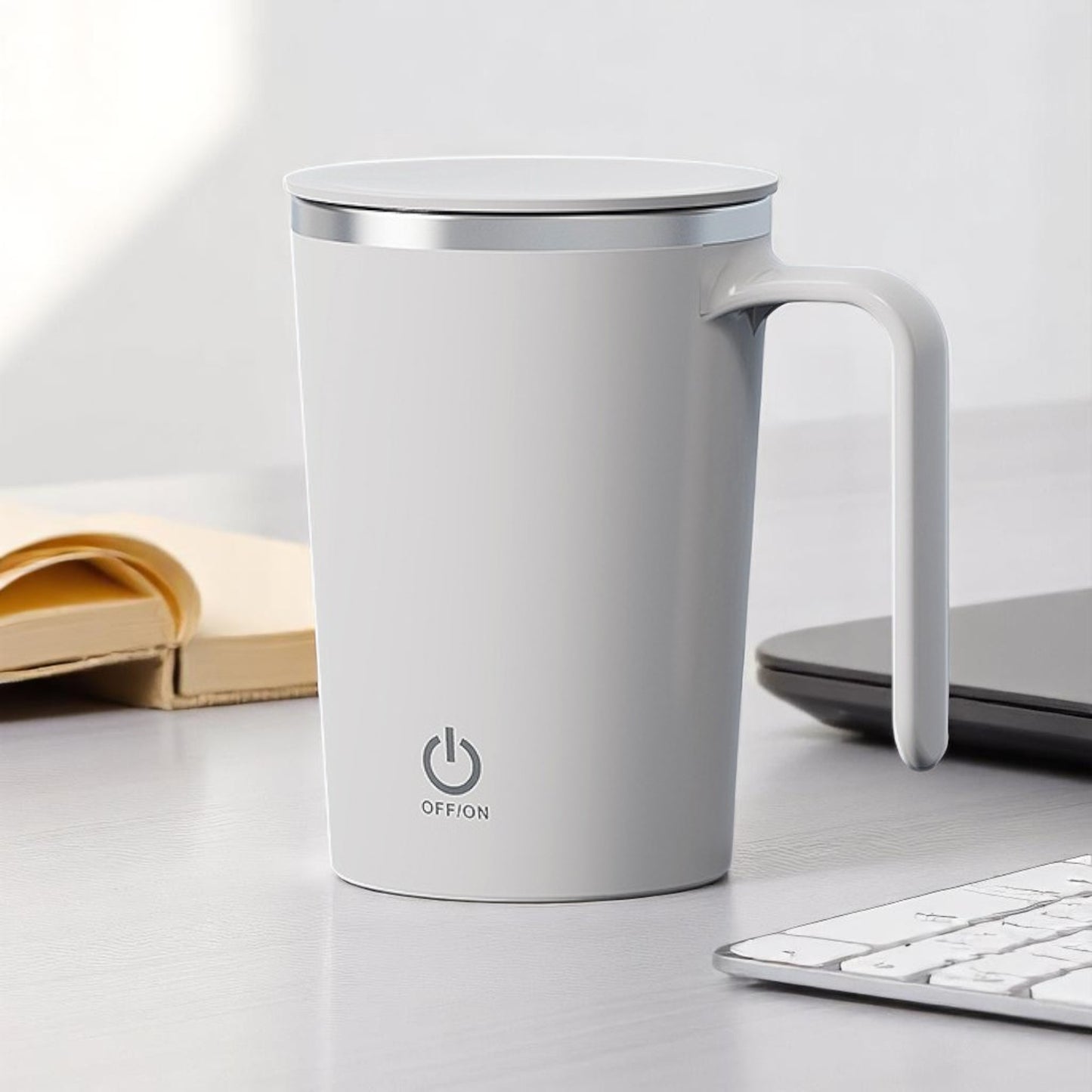 White mug with power symbol on a desk with books and a laptop in the background