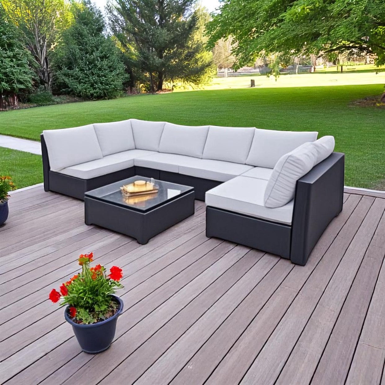 A rattan garden lounge set with blue cushions, including a sofa and a table, placed on an outdoor patio.