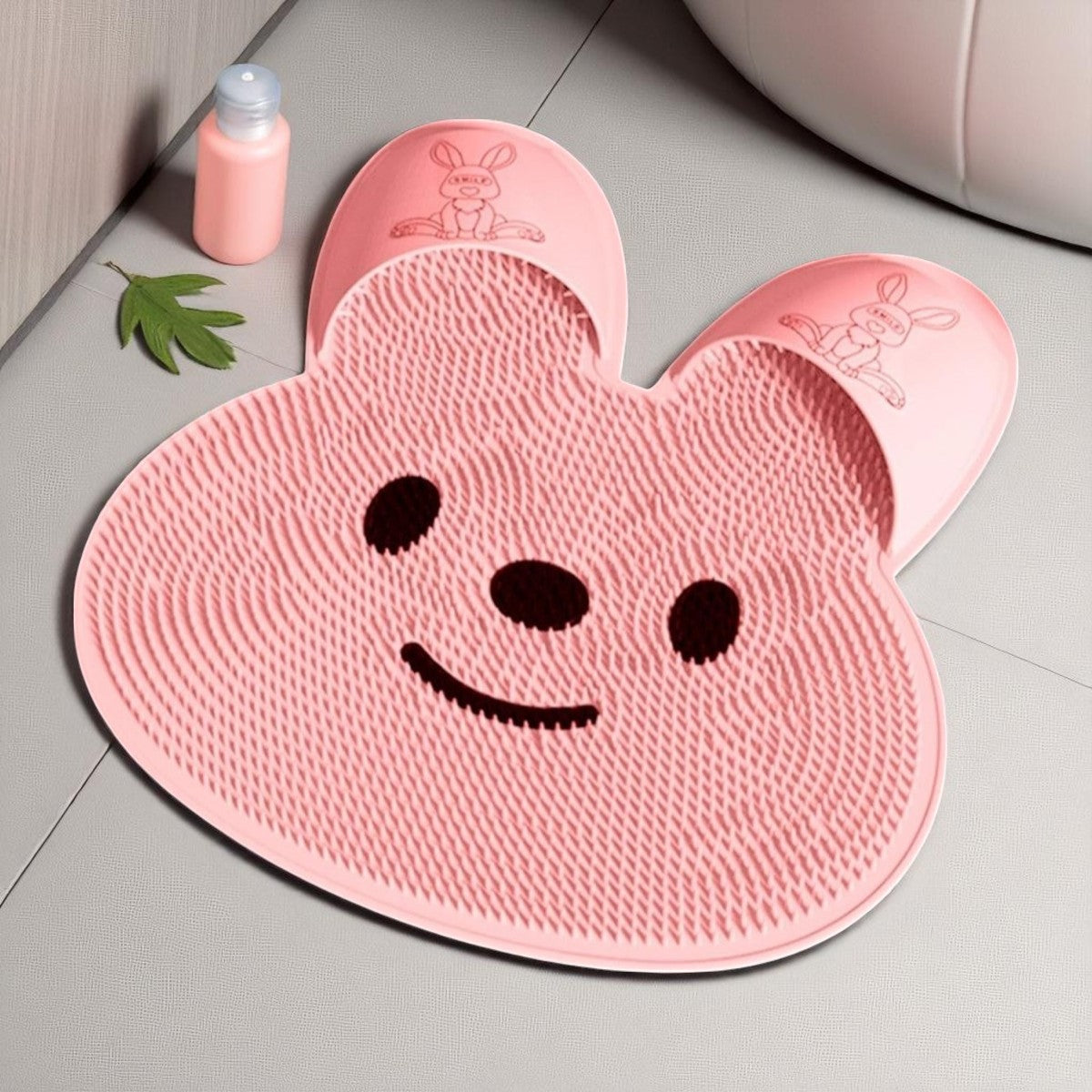 Pink cartoon-style bath mat with a smiley face on a bathroom floor.