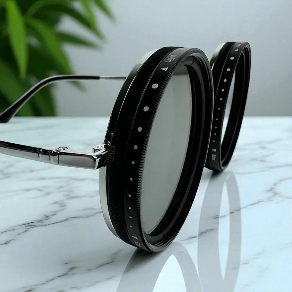 Sunglasses with black frames and silver accents on a marble surface