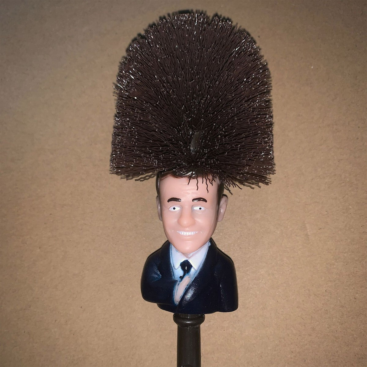 Mannequin head with a bushy hairstyle on a stand against a brown background