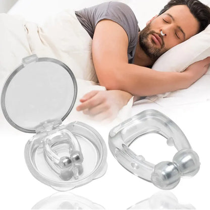 A man sleeping peacefully on a white bed in the background, with two clear silicone nasal dilator devices shown in the foreground, one open to display the inner device and one closed showing the outer device.