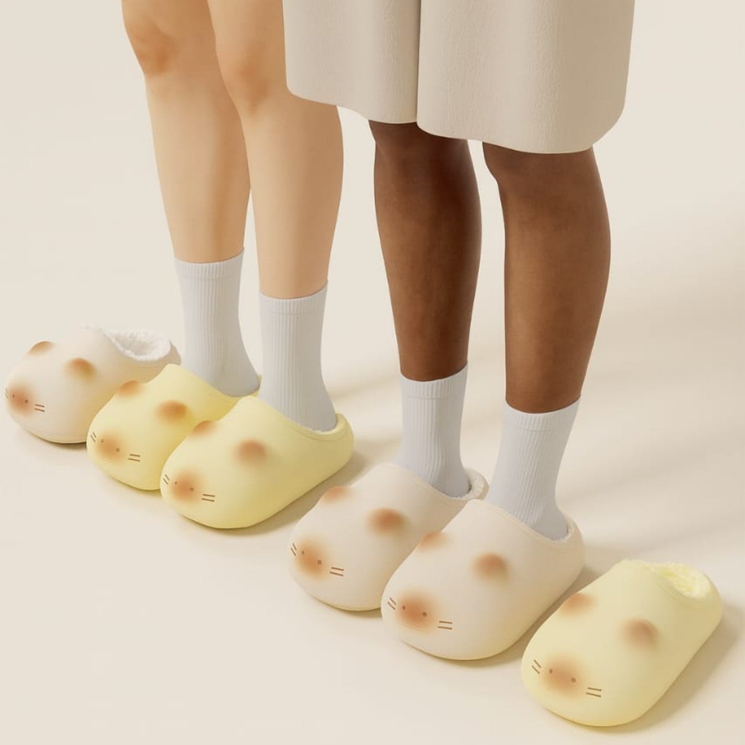Two pairs of yellow cat-shaped slippers worn by people on a beige background