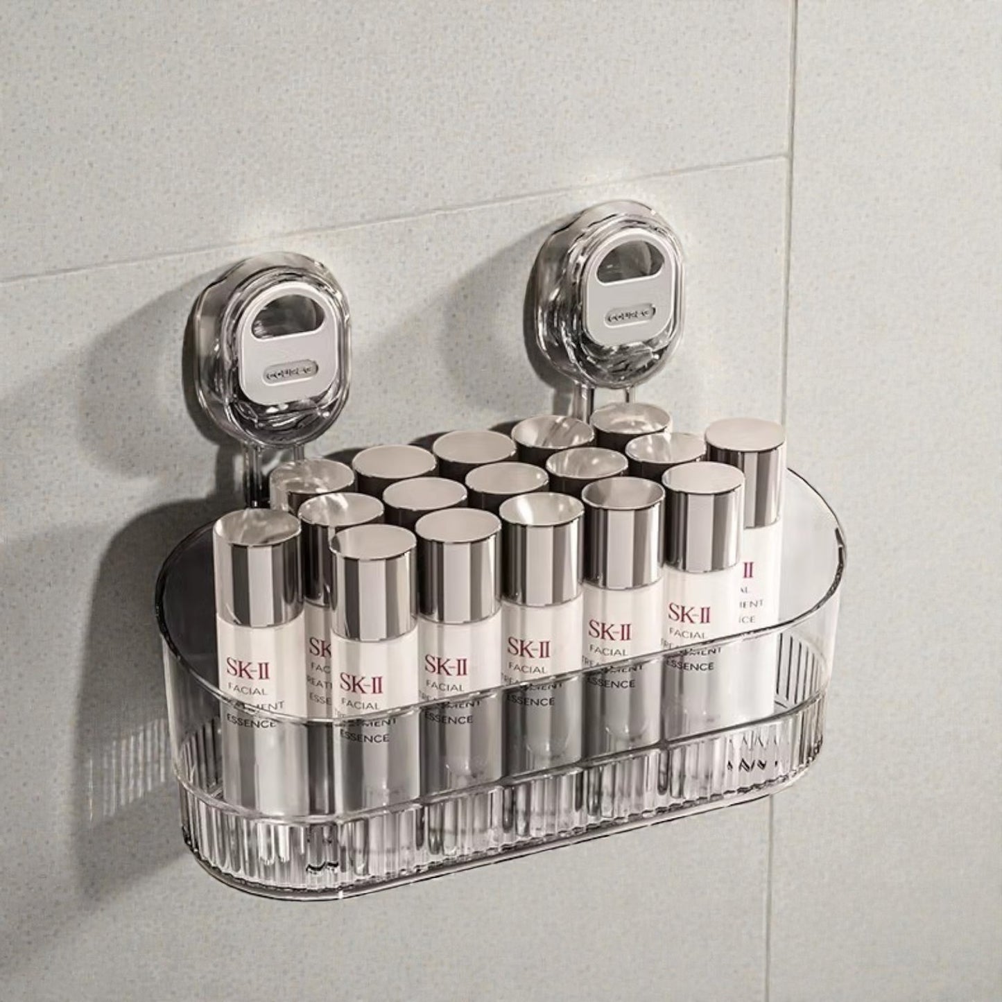 Clear plastic shelf holding multiple SK-II skincare products against a tiled wall.
