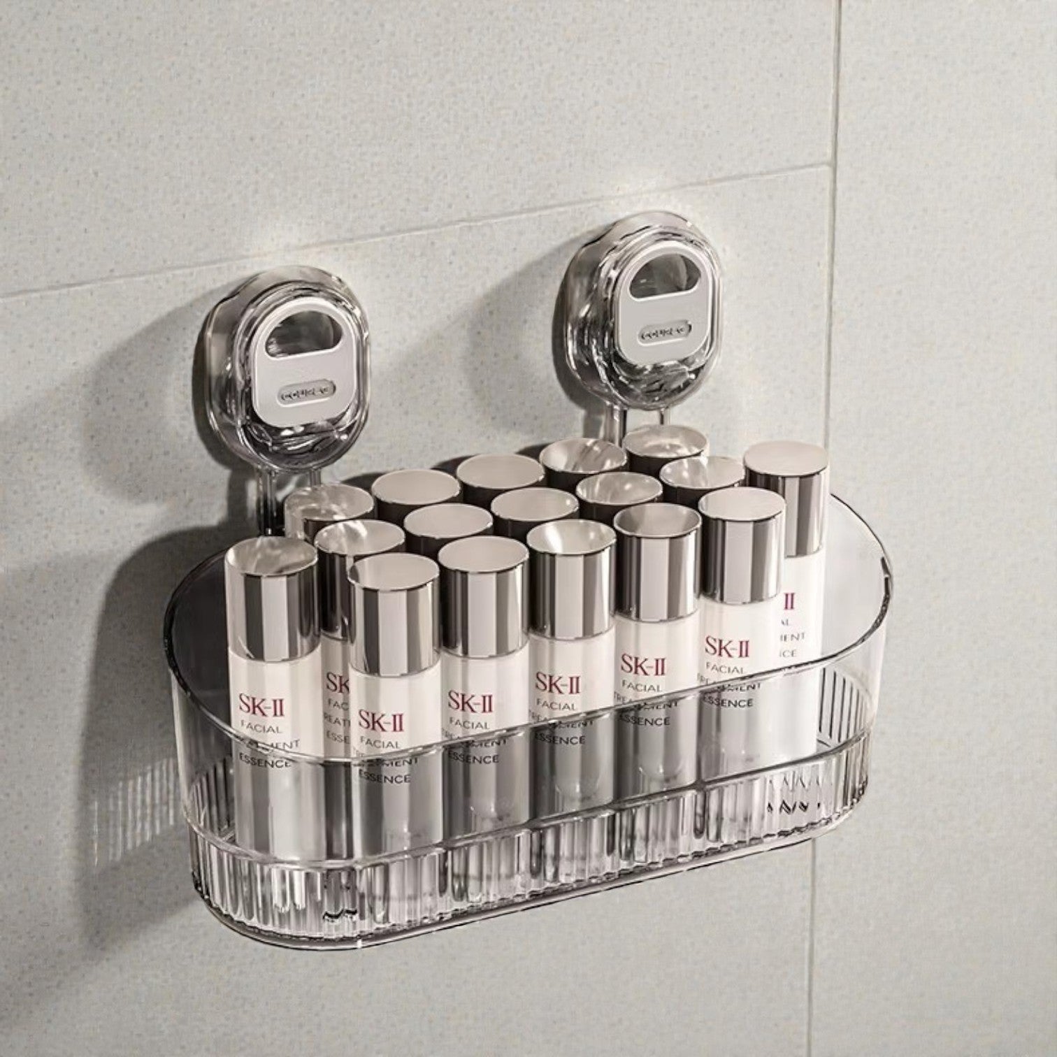 Clear plastic shelf holding multiple SK-II skincare products against a tiled wall.