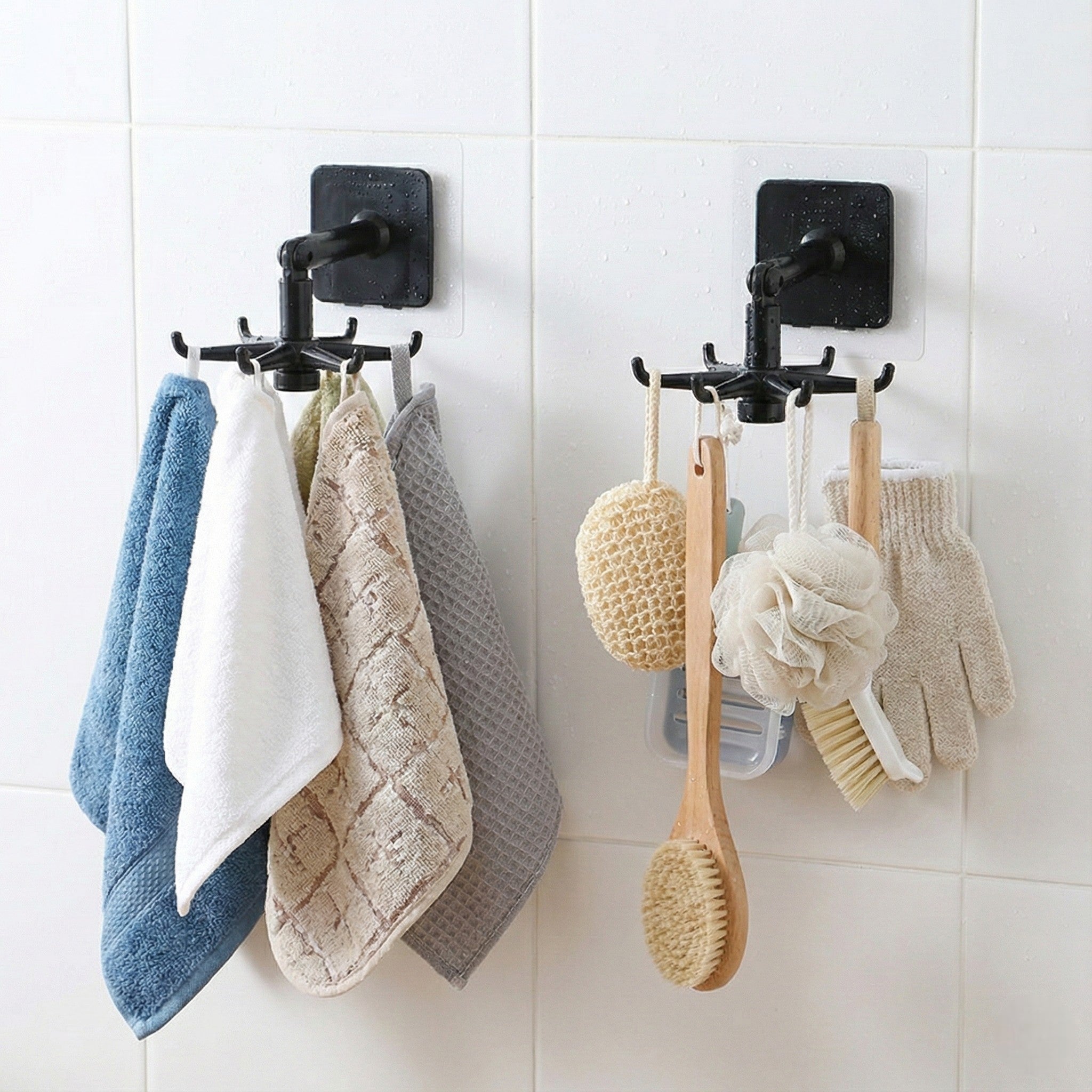 Black wall hooks with towels and bath items on a tiled wall