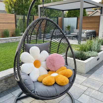 Hanging chair with floral cushions in a garden setting