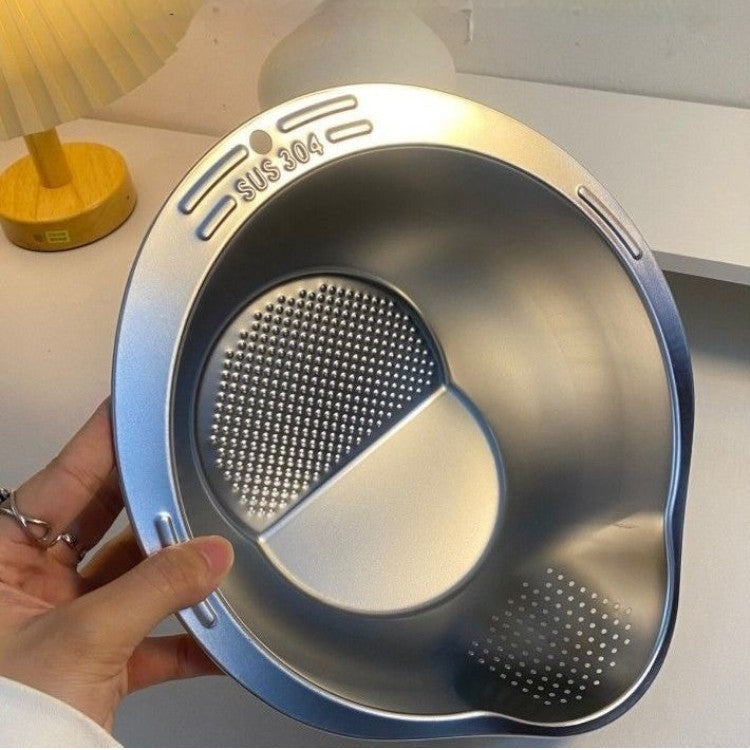 Stainless steel colander with textured sides held by a hand on a light background