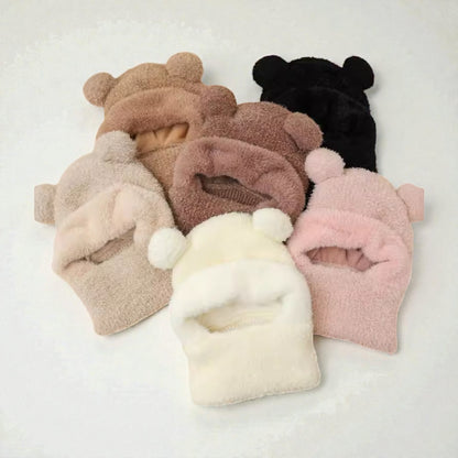 Set of five plush beanies with bear ears in various colors on a light gray background