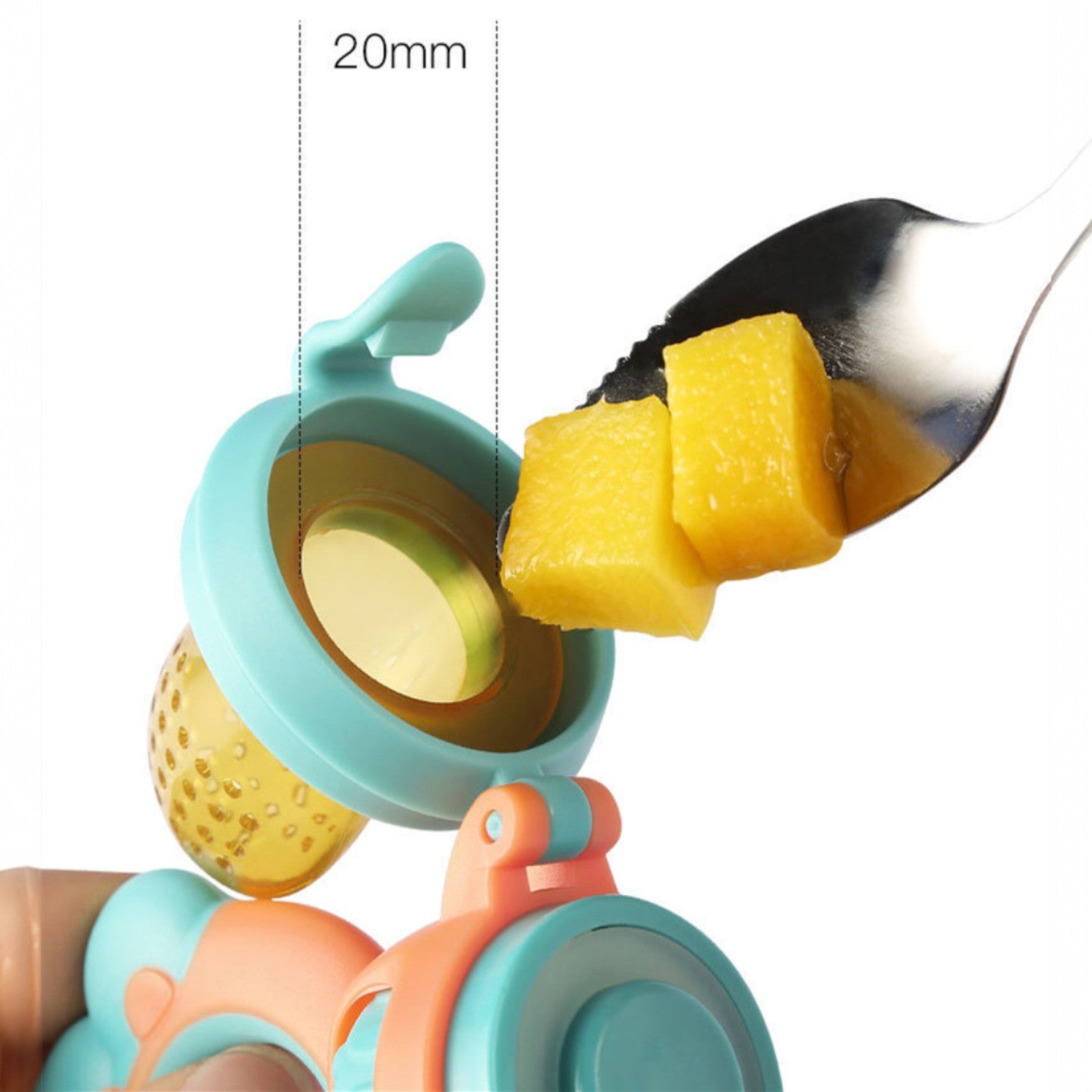 Colorful baby teether with a spoonful of yellow fruit puree on a white background