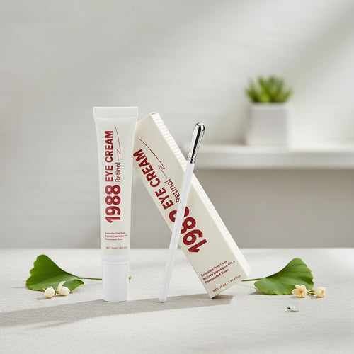 Two tubes of 1988 Eye Cream on a white surface with green leaves and small flowers.