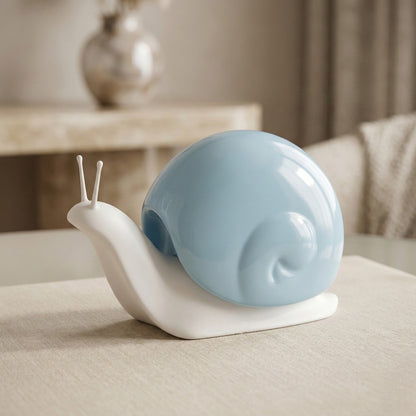 Decorative snail sculpture with a blue shell on a beige surface
