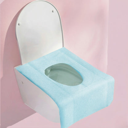 Toilet with a blue seat cover on a pink background