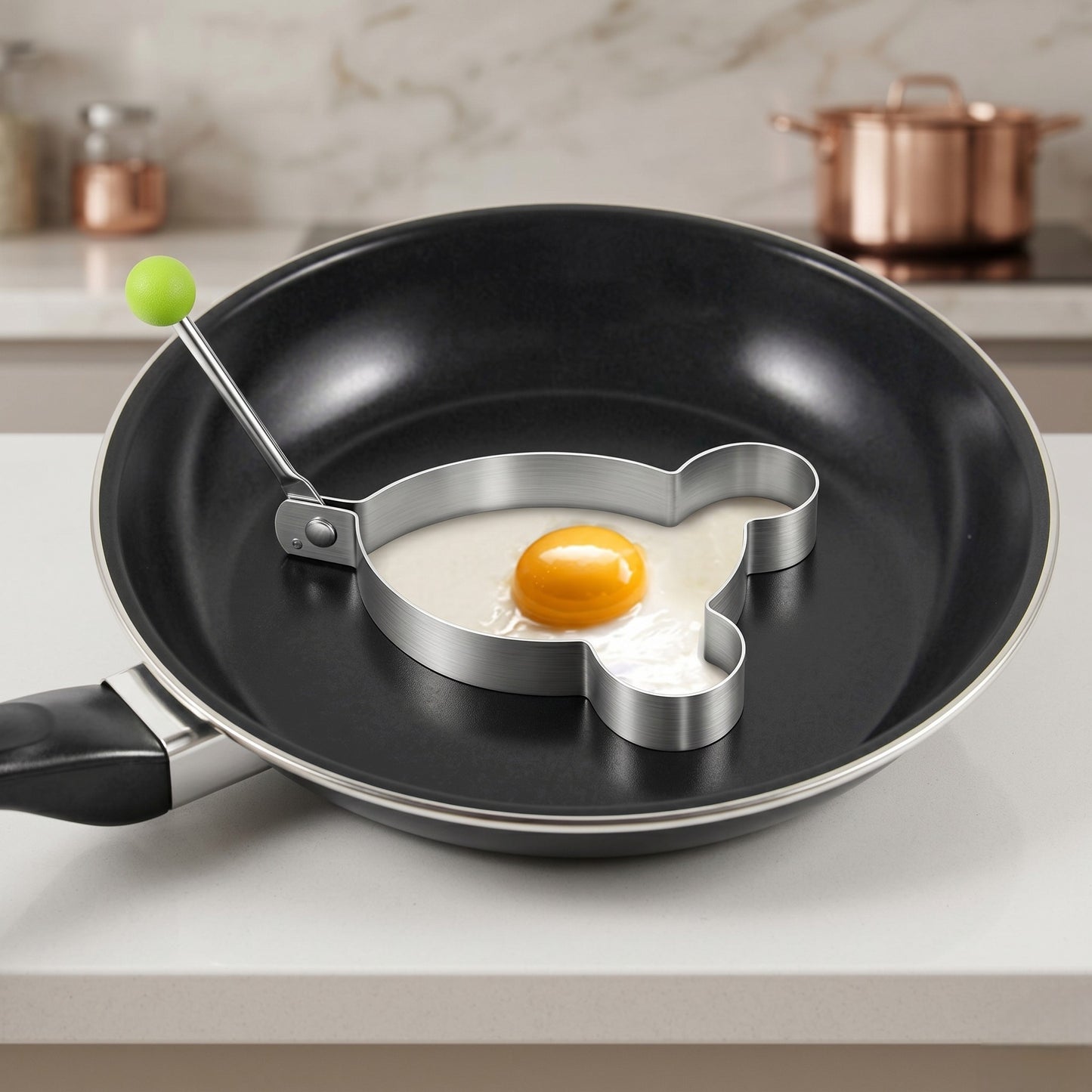 Frying pan with heart-shaped egg ring on a kitchen counter