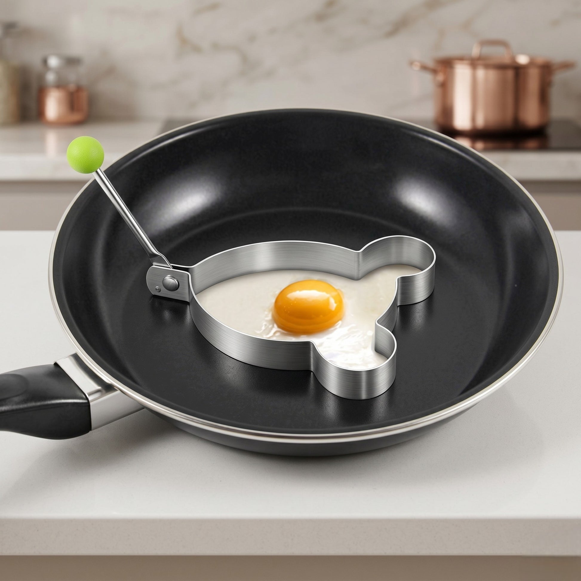 Frying pan with heart-shaped egg ring on a kitchen counter
