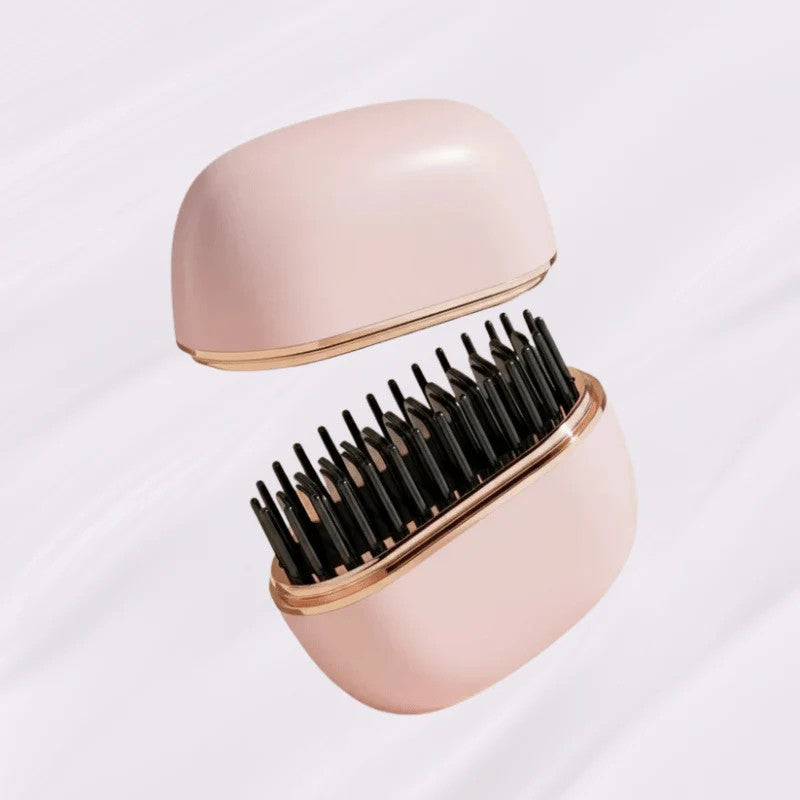 Pink hairbrush with black bristles on a light gray background