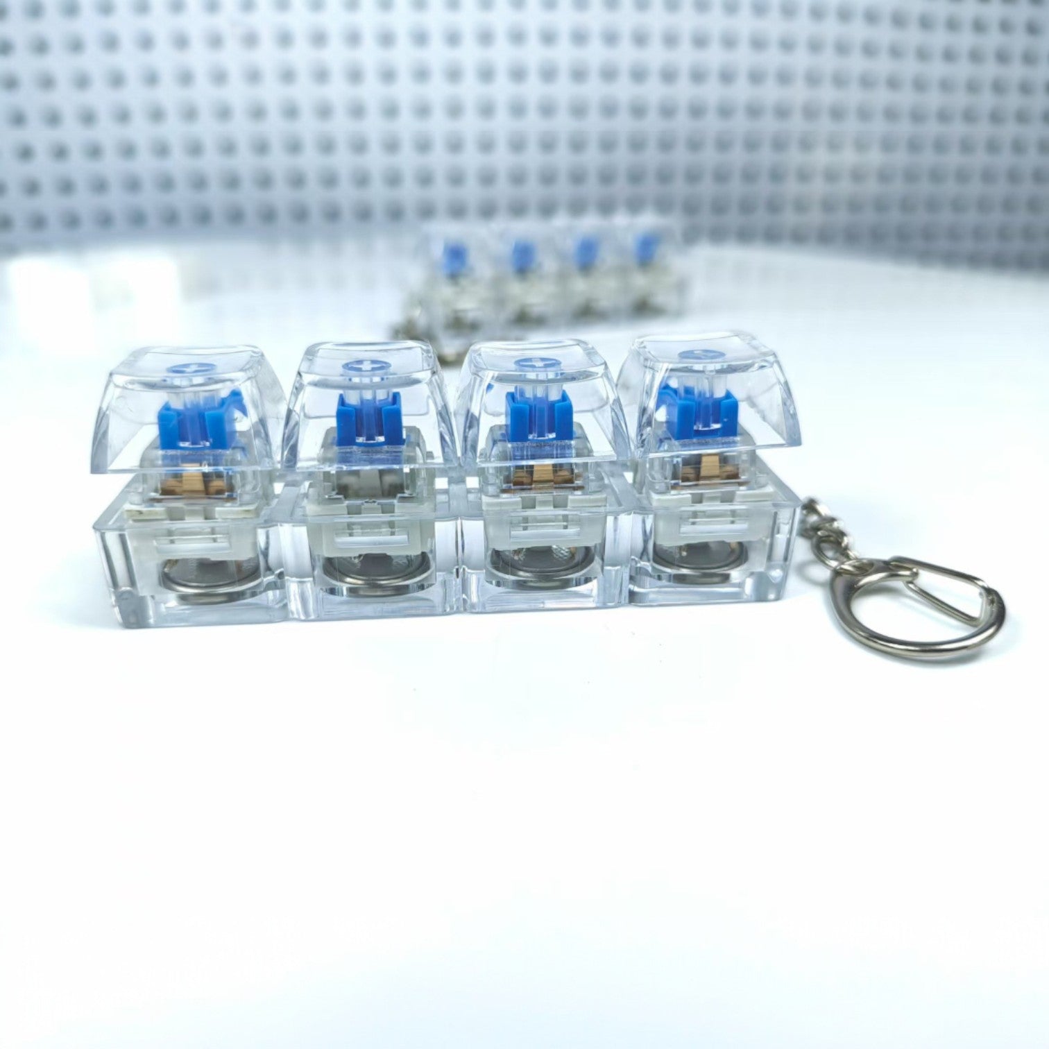 Clear plastic keychain with blue labels on a light gray surface