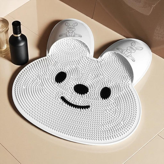 White bear-shaped mat with black eyes and mouth on a beige floor.