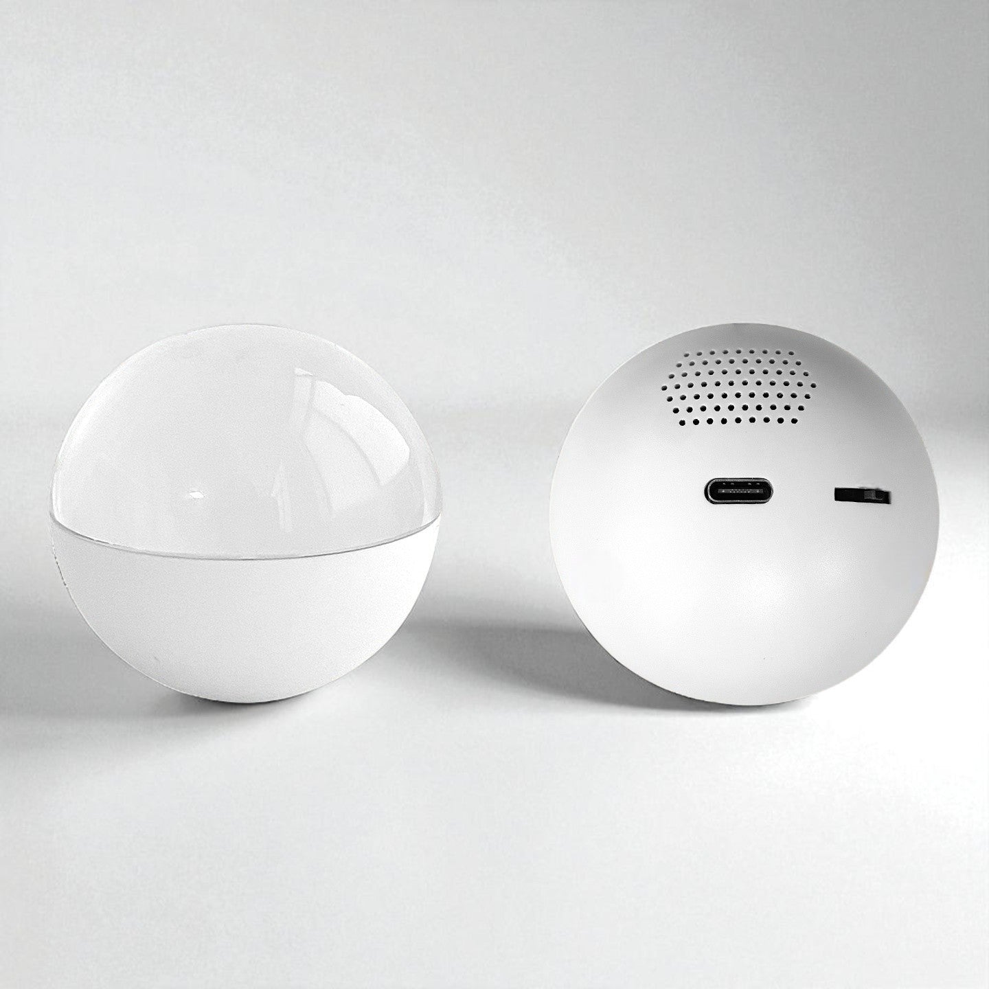 Two white spherical VIDEO PLAYER BALL on a light gray background