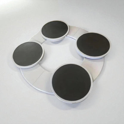 Round white tray with four black circular pads on a light gray background