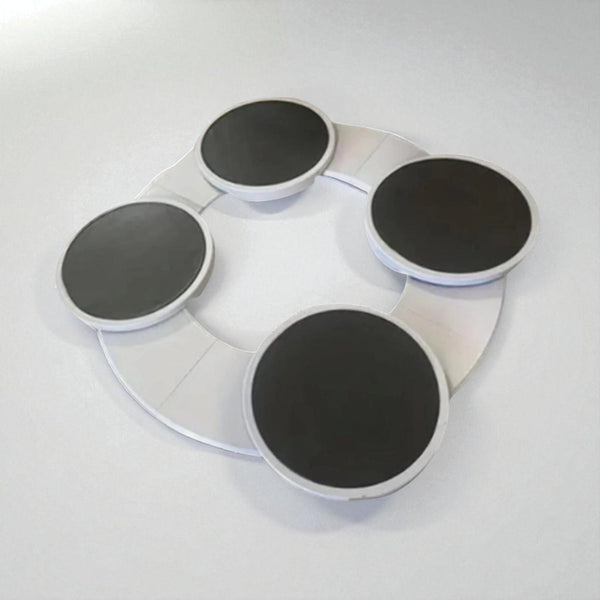 Round white tray with four black circular pads on a light gray background