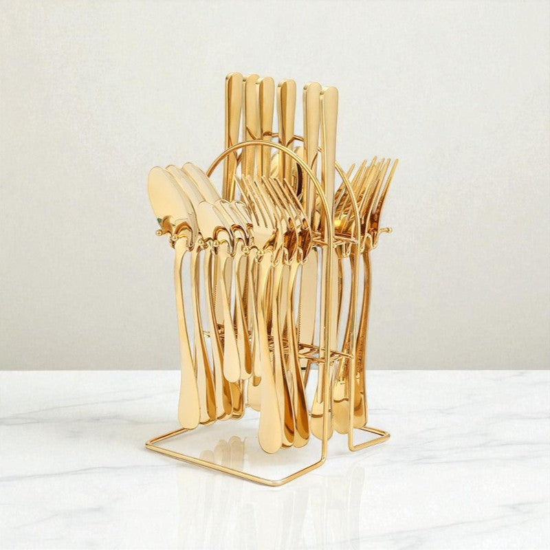 Gold cutlery set in a decorative stand on a white surface