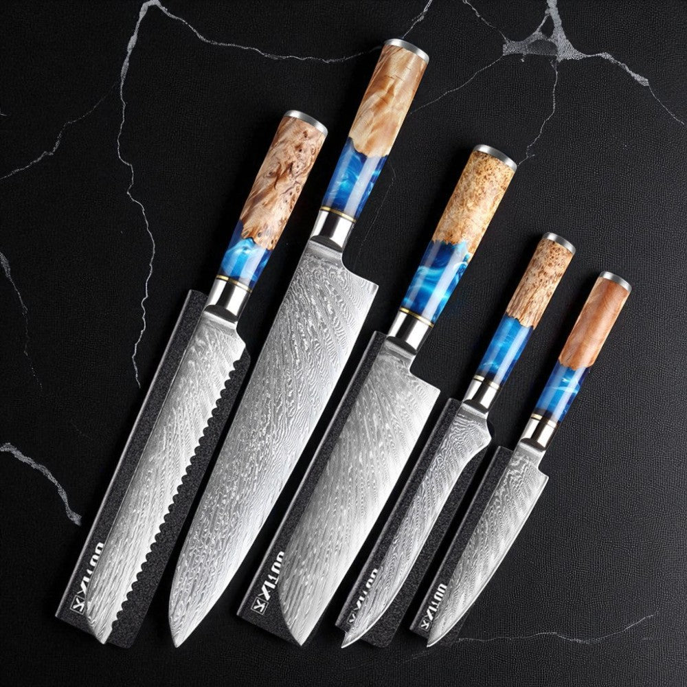 Set of five Damascus knives with wooden handles on a black marble surface